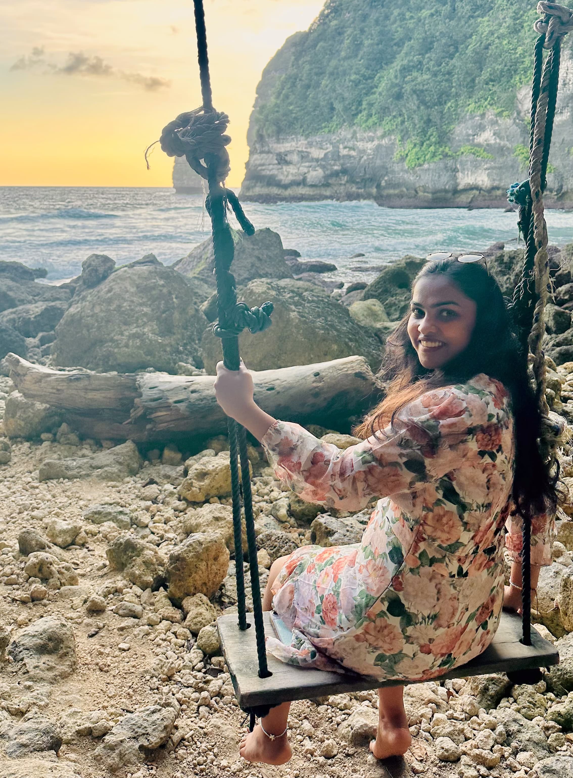 Dinashree sitting on a beach swing during travel