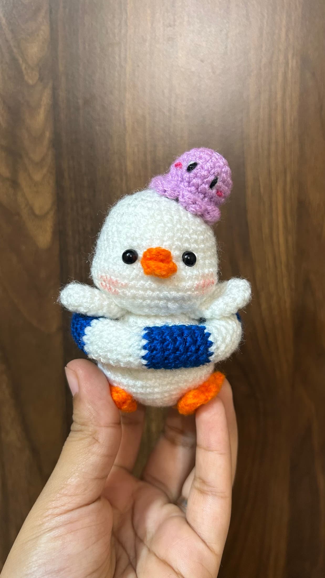 Crochet penguin plush with a tiny purple friend
