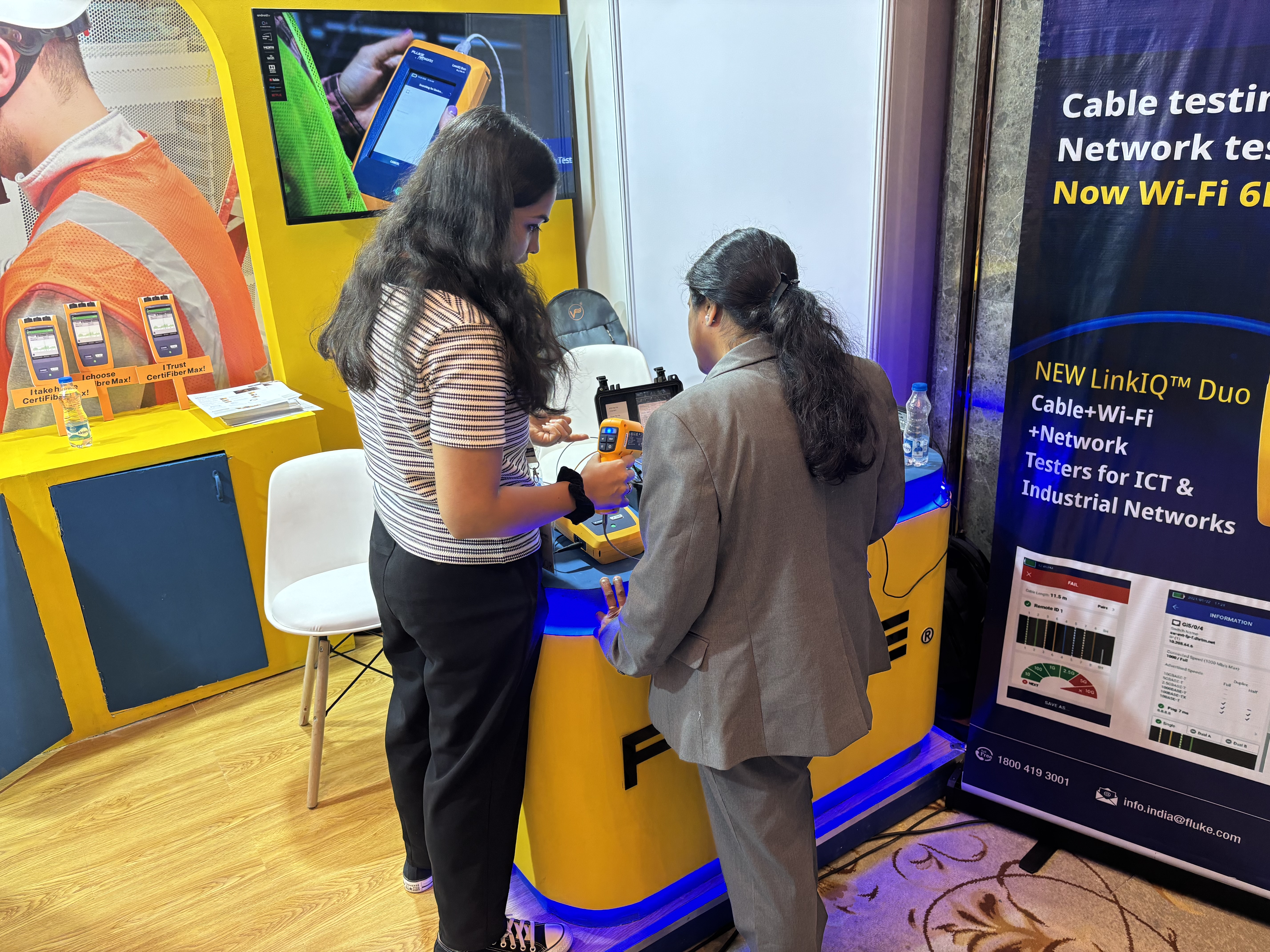 Dinashree walking a customer through a working CertiFiber Max device at the Fluke booth.